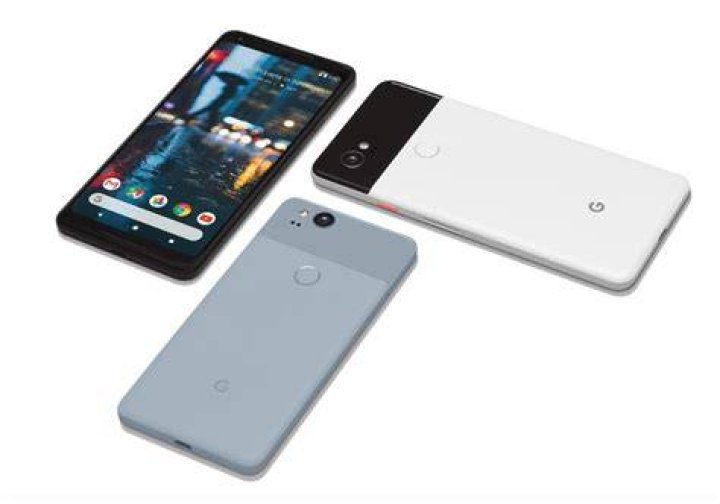 The Google Pixel 2 and the Google Pixel 2 XL, side-by-side, face-up on a white desk.
