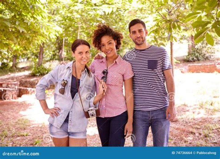 three people posing for a photo with a panda